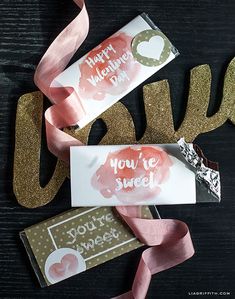 some pink and gold glittered items on a black table with the words you're sweet