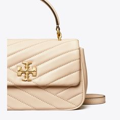 The Kira Top-Handle Bag is made of soft chevron-quilted leather with beveled Double T hardware. Carry it by the top handle or go hands-free with the adjustable crossbody strap. Tory Burch Kira Chevron, Kira Chevron, Chevron Top, Tory Burch Kira, Womens Designer Handbags, Designer Crossbody, Designer Crossbody Bags, Quilted Leather, Handle Bag