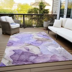 a purple and white rug on a deck with two couches in front of it