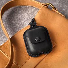 a brown leather bag with a black cell phone in it