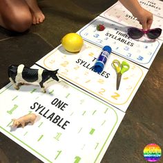 two children are playing with their toys on the floor in front of some cards that read,