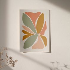 a flower is hanging on the wall next to a potted plant