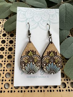 a pair of wooden earrings sitting on top of a card