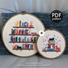 two cross - stitch bookshelves with cats and dogs on them are shown in front of a blue pillow