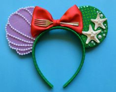 a close up of a minnie mouse ears headband with starfish and seashells on it