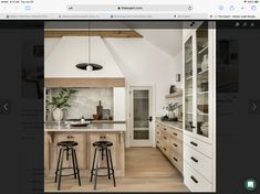 an image of a kitchen with stools and cabinets in the middle of the room