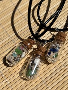 These unique Hawaiian Beach Bottle pendants are approximately 1-1/4 inches long  including the cork and silver eye ring, on an 18 inch cord necklace with extension chain. They contain teeny tiny pieces of beach glass, coral, shells and coarse grain sand  found on Sandy Beach, Honolulu.   In May, I celebrated  my 65th birthday in Oahu as I began to settle into retiring from the corporate world.  Earlier this year I was Inspired by daily walks on the beach at home in West Seattle, Washington and b Bottle Charms Necklaces, Mini Bottle Necklace, Unique Recycled Glass Beach Necklace, Eye Ring Silver, Mini Glass Bottle Necklace, Making Resin Jewellery, Fairy Bottle Necklace, Mermaid Tears, Terrarium Necklace