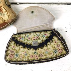 Small vintage petit point handbag with kiss clasp. Tan, gold, blue and pink floral arrangement with scrolls surrounding. Antiqued brass hardware frame with enamel inlay on the front. Clasp has a bezel set warm reddish brown stone or glass cabochon. Made in Austria. Fits an iPhone 6. SIZE 8.25" x 5.25" x 1" CONDITION Good. Gently used. There were originally small stones set in the clasp that have mostly been lost to time. On one side, the fabric is slipping out of the metal frame. AND Small vinta Vintage Rectangular Flap Bag With Gold-tone Hardware, Vintage Handmade Compact Bag, Compact Vintage Gold Coin Purse, Vintage Gold Compact Coin Purse, Vintage Evening Bag With Gold-tone Hardware, Evening Accessories, Envelope Bag, Antique Brass Hardware, Reddish Brown