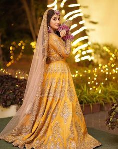 a woman in a yellow wedding dress posing for the camera