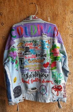 a colorful jacket hanging on the wall with words written all over it and peace signs