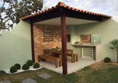 an outdoor kitchen and dining area in a backyard