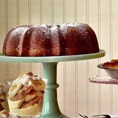 a bundt cake sitting on top of a green plate next to other desserts