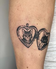 a cat inside a heart shaped locke tattoo on the left thigh, with a black and white image of a cat in it