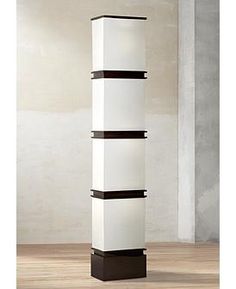 a tall white and black shelf with three shelves on each side in an empty room