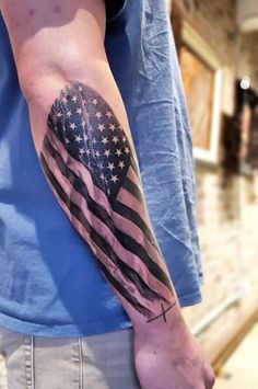 a man's arm with an american flag tattoo on it