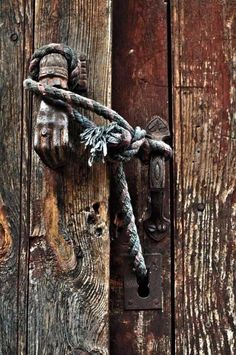 a wooden door with a rope attached to it and a quote written on the front