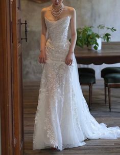 a woman in a white wedding dress standing next to a table