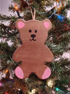 a wooden ornament with a brown bear on it hanging from a christmas tree