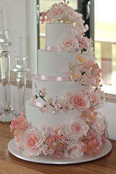 a white wedding cake with pink flowers on top