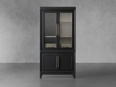 a tall black cabinet with glass doors on the top and bottom shelf, in front of a concrete wall