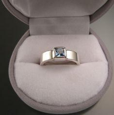 "5 mm square scissors-cut blue Topaz is bezel set with stout 2mm thick by 5mm wide rectangular band. These are beautifully cut, eye clean stones with top sky blue color. I can make this ring for you in any size between 5 and 11. Pictured ring is size 7 for scale. Specify your ring size in a \"note to seller\" at checkout." Silver Topaz Ring With Rectangular Blue Stone, Silver Blue Topaz Ring With Rectangular Stone, Silver Rectangular Topaz Ring, Rectangular Silver Topaz Ring, Rectangular Silver Blue Topaz Ring, Modern Rectangular Topaz Wedding Ring, Gift Blue Topaz Ring With Rectangular Shape, Gift Blue Topaz Rectangular Ring, Modern Rectangular Sapphire Ring For Anniversary