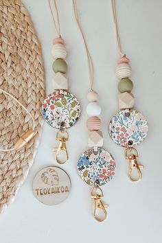 three keychains with different designs on them and a tag hanging from the side