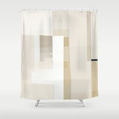 a white shower curtain with beige and black squares on the bottom, in front of a gray background