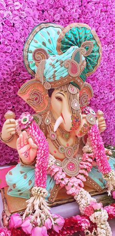 an elephant statue is surrounded by pink flowers