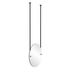 an oval mirror hanging from the ceiling with two black poles and one round mirror above it