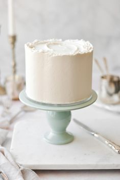 a white frosted cake sitting on top of a table