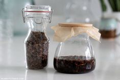 two glass jars filled with different types of food on top of a white countertop