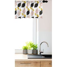 a kitchen window curtain with black and white flowers on it