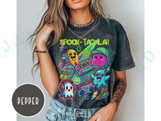 Celebrate Halloween in Y2K style with this vibrant and fun "Spook-tacular" T-shirt! This Comfort Colors Tee features an eye-catching design with neon-colored ghosts rocking retro gear. The ghosts are decked out with cassette tapes, boomboxes, high-top sneakers, and headphones, bringing a nostalgic Y2K twist to the Halloween season. The playful graphics and bold colors make this tee perfect for any Halloween party or casual wear, combining the best of early 2000s fashion with a spooky vibe. Comfo Trendy Halloween Concert T-shirt, Halloween Rave Tops With Graphic Print, Rave Tops With Graphic Print For Halloween, Halloween Y2k, Neon Halloween, Playful Graphics, Clothes Wishlist, Y2k T Shirt, Early 2000s Fashion