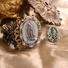 This ring is inspired by sentimental vintage French jewelry, Our Lady, Mary, mother of Jesus, stands in an oval frame with tiny flowers and leaves set with ice crystal. The frame is inscribed with the verse of the Miraculous Medal, a prayer for intercession and assistance. "O Mary conceived without sin pray for us who have recourse to thee." Choice of silver finish with pale turquoise lacquer background or burnished bronze. åÊ Adjustable, comfortable ring band fits sizes 6-9. Made in our Los Angeles studio. åÊ From our Artifacts Ring Collection featuring old world icons of beauty, mystery and a hint of magic. Enduring symbols of legend, inspiration and guidance, they connect past with present for this journey called life. Using traditional bench techniques, every ring is hand-fabricated wi Virgin Mary Ring, Guadalupe Bracelet, High Neck Bodycon Dress, Hippie Wedding, Locket Bracelet, Lady Mary, French Jewelry, Our Lady Of Guadalupe, Lady Of Guadalupe