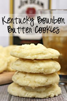 a stack of butter cookies sitting on top of a table next to a bottle of bourbon