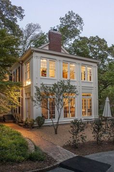 a large white house sitting in the middle of a forest