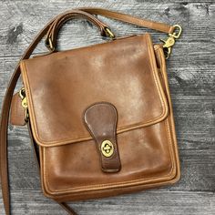 This Vintage Coach Messenger Bag Is A Stylish Addition To Any Collection. With A Beautiful Brown Leather Exterior And Gold Hardware, This Medium-Sized Bag Is Perfect For Any Woman On The Go. The Bag Features A Turn Lock Closure And A Detachable Strap For Versatile Carrying Options. The Interior Is Lined With Soft Suede In A Matching Brown Color And Features Enough Space For All Your Essentials. The Bag Measures 9 Inches In Width And 10 Inches In Height, Making It The Perfect Size For Everyday Use. Whether You're Running Errands Or Heading To The Office, This Bag Is Sure To Impress. Note This Is A Vintage Bag And Has Clear Wear And Tear But Still Has Tons Of Life Left. The Leather Coach Tag Vintage Coach Messenger, Coach Messenger Bag, Brown Leather Messenger Bag, Vintage Coach Bags, Medium Sized Bags, Bags Vintage, Leather Coach, Vintage Bag, Leather Messenger Bag