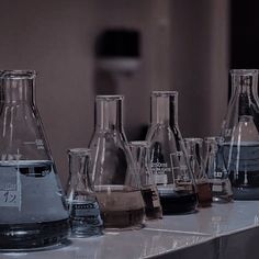 many different colored liquids in glass beakers on a counter