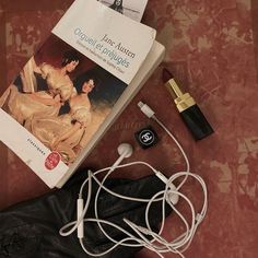 the contents of a pair of headphones are laid out next to a book and earbuds