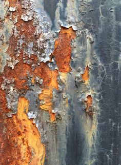 an old rusted metal surface with orange and white paint