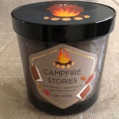 a candle that is sitting on the floor next to a table top with a label reading campfire stories