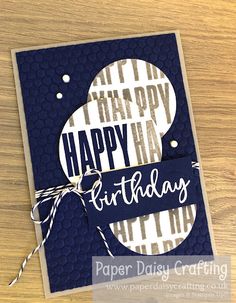 a birthday card with the words happy birthday written in white and blue on it, sitting on a wooden table