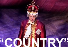 a man wearing a crown and standing in front of a purple background with the words country on it