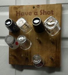 a wooden sign that says have a shot with four different shots in each glass on it