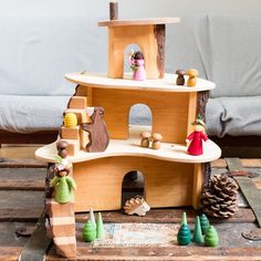 a wooden toy house with figurines on it