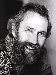 black and white photograph of a man with a goatee smiling at the camera,