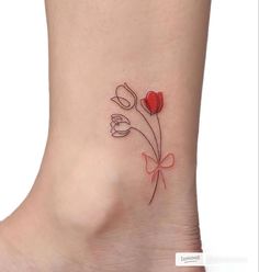 a small flower tattoo on the ankle with red and white tulips in it