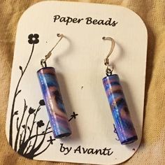 the earrings are made out of glass and have purple, blue and white designs on them