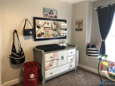 a baby's room with a dresser, crib and toy bag hanging on the wall