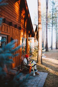 a person sitting on a bench in front of a cabin